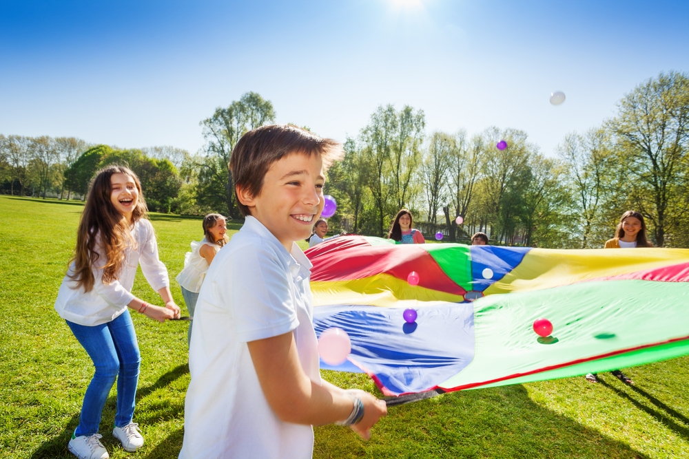 Boy,Throwing,Balls,Up,By,Using,Rainbow,Parachute