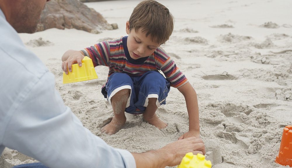 child playing in the sand at the beach