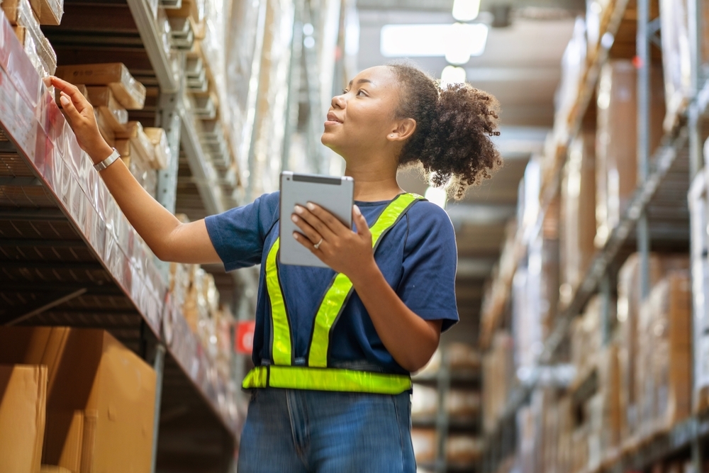 woman holding a tablet checks inventory and checks orders from customers to deliver documents to customers in a warehouse wholesale store.