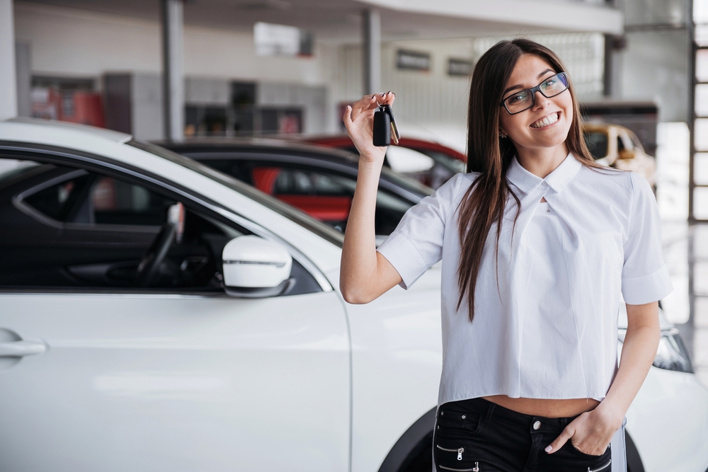 Young,Happy,Woman,Near,The,Car,With,Keys,In,Hand