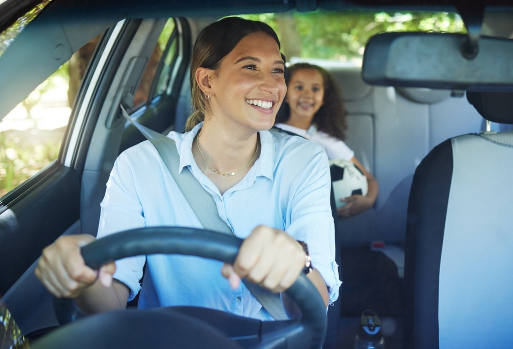 Mom, driver and girl passenger in vehicle, smile and bonding on road trip